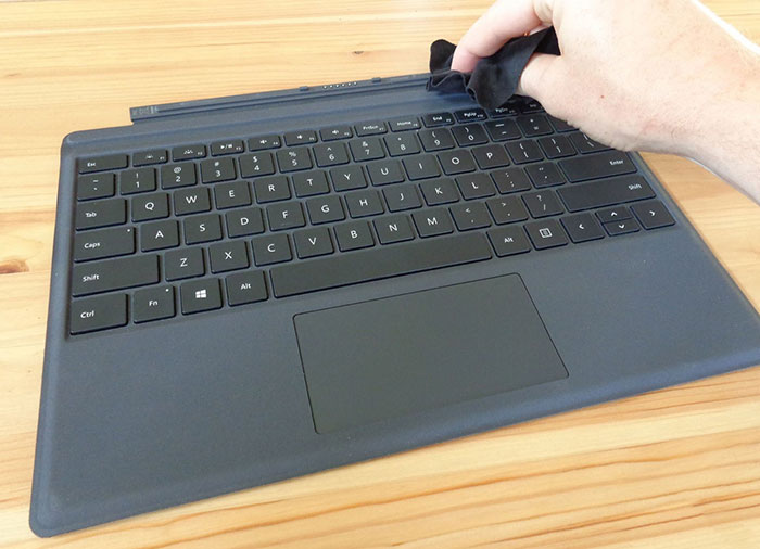 Bạn hãy vệ sinh qua phần chân bàn phím máy bằng khăn giáy hoặc giẻ